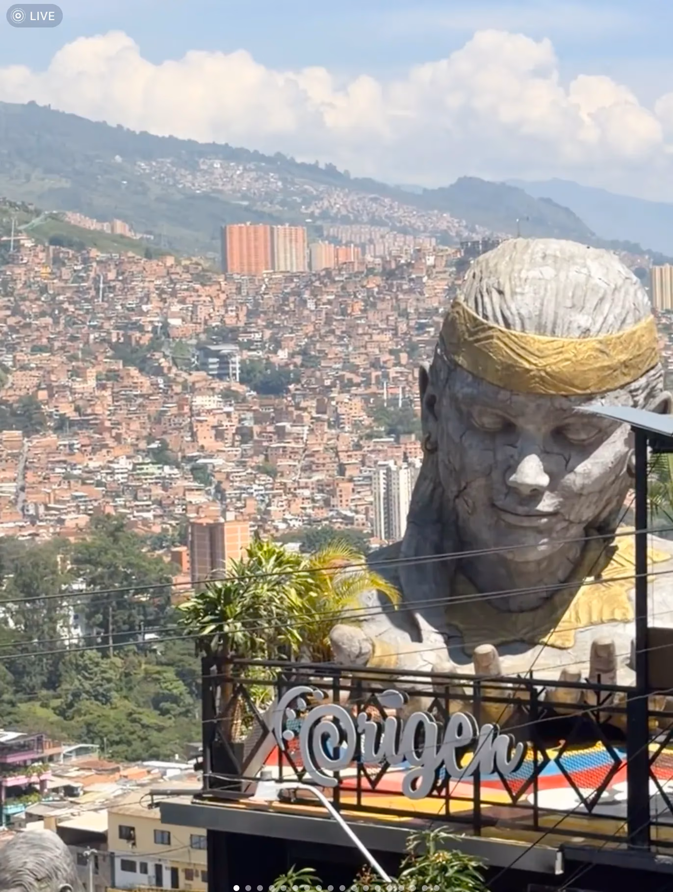 A real-world photo used as a Qwen vision-benchmark demo image, showing a large statue-like landmark overlooking a dense hillside cityscape, used to test the model's real-world location and scene understanding on benchmarks like RealWorldQA.
