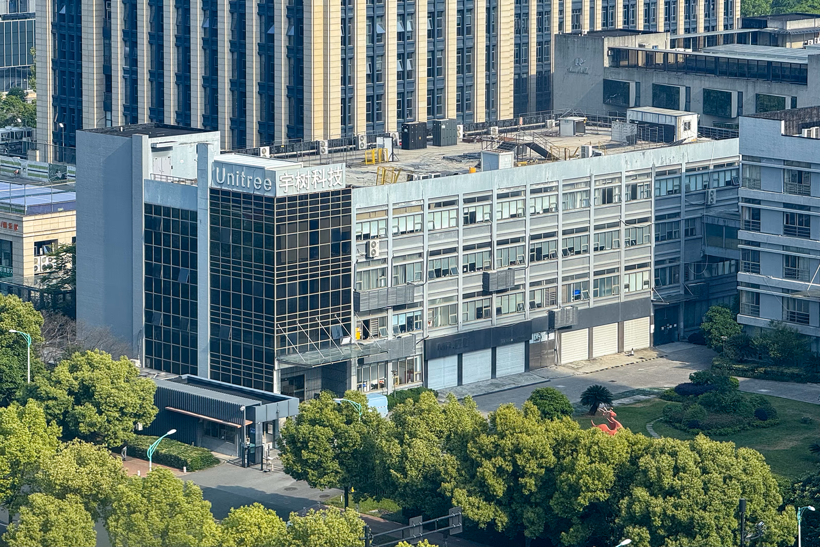 Aerial photograph of Unitree's headquarters building in Hangzhou, China, with 'Unitree 宇树科技' signage visible on the exterior.